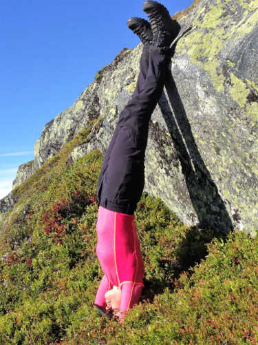 Ingrid Solberg Sætre står på hode ute i naturen på fjellet
