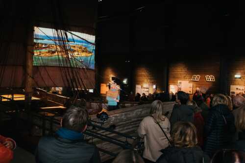 Eventyrer Randi Skaug holder foredrag oppe i båt på Jektefartsmuseet.