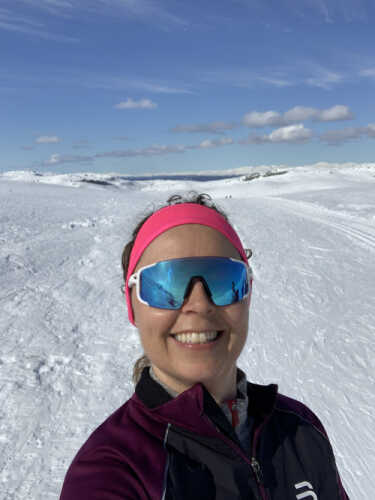 Nærbilde av Kristin med pannebånd og solbriller i vinterlandskap.