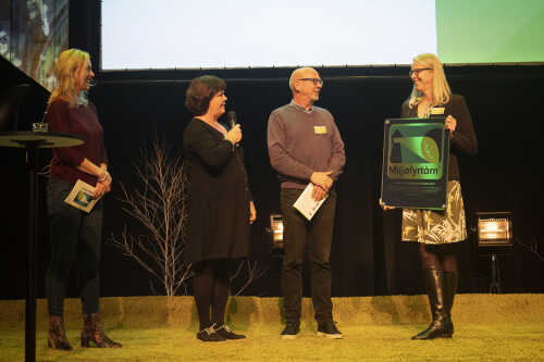 Bilde av 3 fra Mimir på scenen som mottar Miljøfyrtårn-sertifisering av Norsk Opplevelseskonferanse 2019.