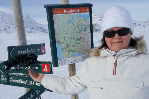 Marie på skitur foran stedsskilt på fjellet