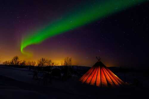 Bilde av samisk telt med nordlys på himmelen